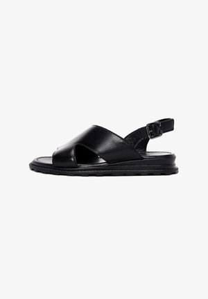 Schwarze Ledersandalen verfügen über ein Kreuzriemen-Design, eine verstellbare Schnalle, offene Zehen und eine strukturierte Sohle für besseren Halt.