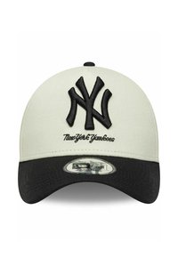 Casquette de baseball ajustable avec une couronne blanche, une visière noire, présentant un grand logo brodé noir "NY" et le texte "New York Yankees".