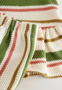 Gestrickte Decke mit cremefarbigem Grund, die strukturierte Streifen in Grün, Rosa und Gold aufweist. Mit kontrastierendem Strickrand für zusätzliche Details eingefasst.