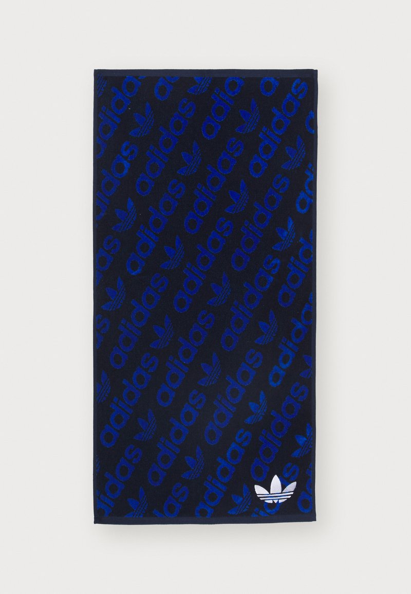 Navy towel featuring a repeated blue "adidas" logo pattern and a white trefoil logo accent at the bottom right corner. Soft texture.