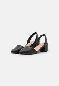 Tacones slingback de imitación de cuero negro con punta afilada, patrón de cocodrilo texturizado y un tacón bloque modesto.