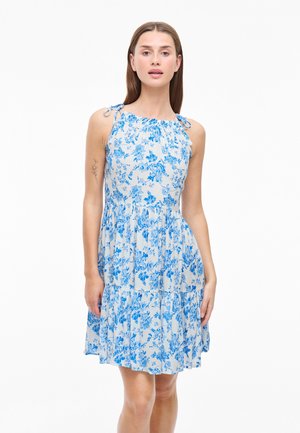 Robe florale bleue avec un design sans manches, un col froncé et des bretelles à nouer. Le tissu a une texture légère et un ourlet à volants.