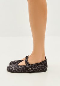 Flat shoes in black and gray leopard print fabric, featuring a Mary Jane strap with a metal buckle and a rounded toe design.