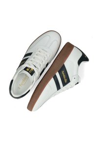 Sneaker bianche in pelle con strisce nere, suola in gomma marrone e dettagli di branding dorati. Design con lacci, linguetta piatta e accenti di cucitura.