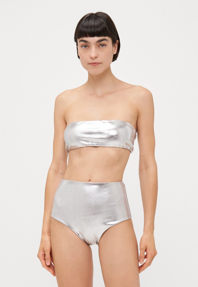 Top de bikini bandeau metalizat argintiu și bottom cu talie înaltă. Textură netedă, design fără cusături și finisaj strălucitor.