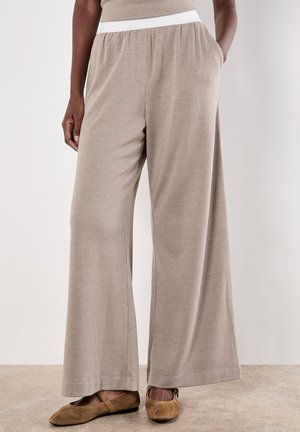 Beige weite Hose mit strukturiertem Muster und einem weißen elastischen Bund, ausgestattet mit Seitentaschen und einer lässigen Passform.