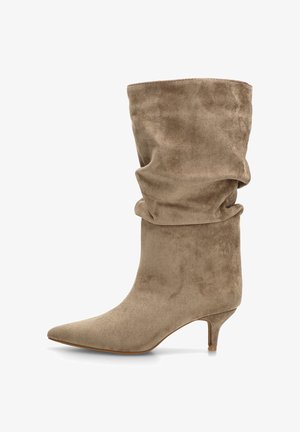 Botín de ante topo con diseño holgado, punta afilada y tacón fino tipo kitten. Textura suave con una apariencia aterciopelada.