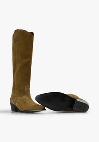 Botas altas de ante en un color marrón apagado, con punteras puntiagudas, un tacón bajo en bloque y detalles de costura blanca en contraste.