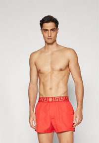 Κόκκινα μαγιό σορτς από ελαφρύ ύφασμα, με ζώνη μέσης με λογότυπο και αντίθετο σχέδιο ελληνικού κλειδιού, καθώς και ελαστική σχεδίαση για άνεση.