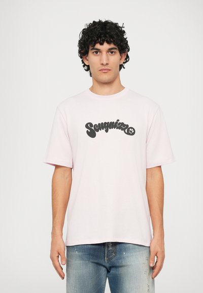 Lichtroze katoenen t-shirt met korte mouwen en een ronde halslijn. Heeft een zwart grafisch tekstlogo in het midden op de voorkant.