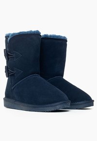 Botines de ante azul marino con forro de piel sintética, que cuentan con dos cierres de toggle decorativos y una suela de goma texturizada.