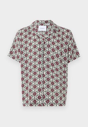 Chemise à manches courtes en tissu léger, avec un motif floral rouge et vert sur fond crème, dotée d'un col classique et d'une fermeture à boutons.