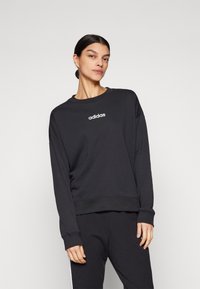 Fekete kapucnis pulóver pamut keverékből, hosszú ujjakkal, kerek nyakkivágással és fehér "adidas" logóval a mellkason.