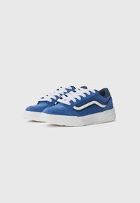 Blaue Wildleder-Sneaker mit weißen Schnürsenkeln und weißer Außensohle. Verfügt über ein seitliches Logo und perforierte Akzente für Atmungsaktivität. Modernes Design.