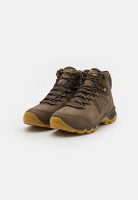 Brązowe buty trekkingowe z zewnętrzną częścią z zamszu i siateczki, gumową podeszwą, wyściółką kołnierza i kontrastującymi żółtymi akcentami. Posiada wzmacniane przelotki.