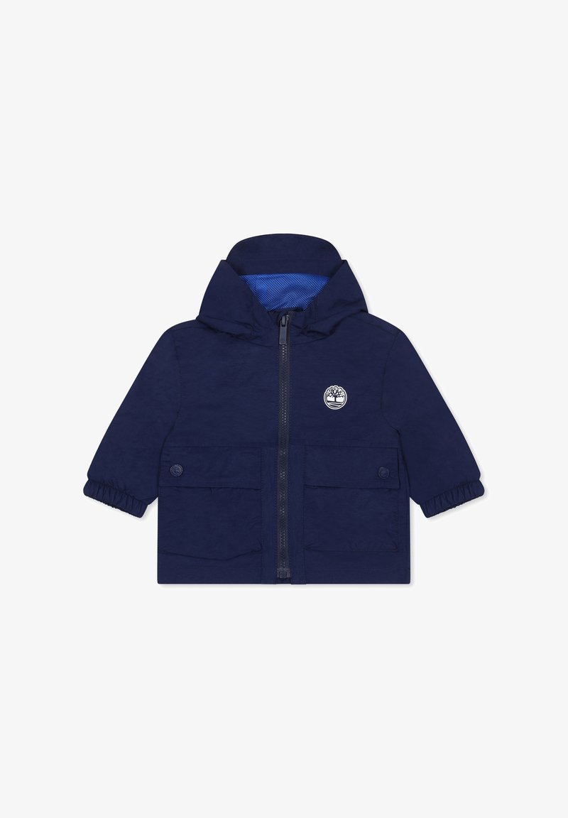 Veste pour enfants bleue marine en matériau léger, avec une fermeture éclair à l'avant, une capuche, deux poches avant et une doublure en filet intérieur.