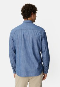 Herrenlangarmhemd aus hellblauem Chambray-Stoff, mit einem Button-Down-Kragen und einem geraden Saum mit Zwei-Knopf-Manschetten.