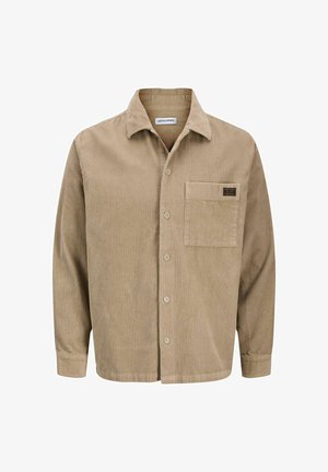 Chemise en velours côtelé beige avec un devant à boutons, un col pointu, une poche poitrine unique et une texture côtelée discrète. Étiquette de marque sur la poche.