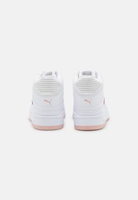 Białe sneakersy z teksturowanym tyłem, różowymi akcentami i okrągłym kształtem. Posiadają wyściełaną krawędź i markowy logo po boku.