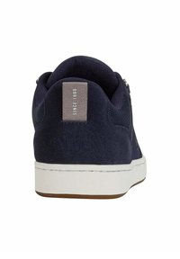 Baskets bleu marine avec des matériaux en daim et en maille, semelle en caoutchouc blanc, patte de talon avec logo et étiquette indiquant "Depuis 1966".