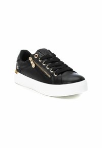 Zapatillas de cuero negro con diseño de cordones, que presentan una cremallera decorativa y detalles en dorado. La gruesa suela blanca aporta contraste.