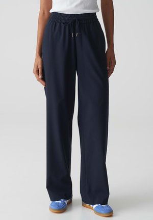 Navy blue, wide-leg, elastic waist pants with drawstring. Made of soft fabric, featuring a smooth texture and minimal detailing.