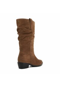 Bottes en suède marron au-dessus du genou avec un design décontracté, un bout arrondi et un petit talon noir, présentant des détails de couture subtils.