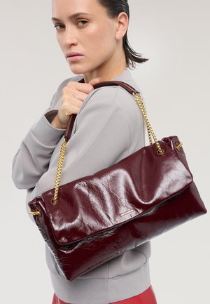 Borsa a mano in pelle color bordeaux con una texture increspata, dotata di una lunga tracolla a catena dorata e un design elegante e minimalista.