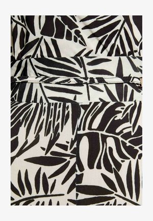 Tissu à motif de feuilles tropicales en noir et blanc, avec ceinture étroite assortie et détail de boucle dorée.