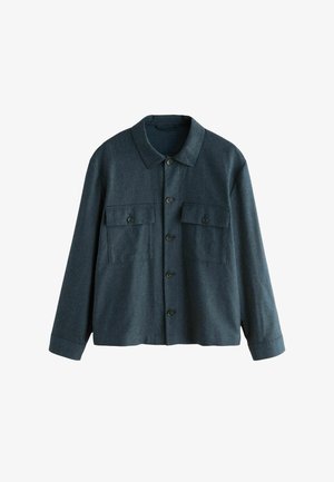 Sötétszürke gyapjúkeverék dzseki gallérral, két mellzsebbel és elülső gombos záródással. Hosszú ujjakkal és laza szabással rendelkezik.