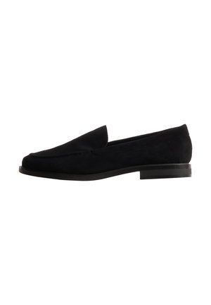 Mocassin slip-on en daim noir avec petit talon et bout arrondi, montré de profil sur fond blanc.