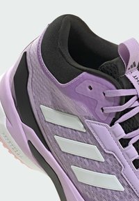 Purple athletic shoe with a textured upper, black accents, and three white stripes. Lightweight design with durable rubber sole and lace-up closure.
