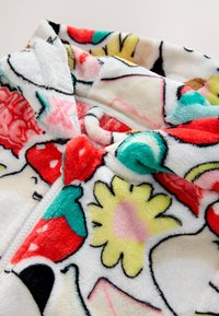 Felpa con cappuccio bianca e morbida con cerniera, decorata con motivi colorati di frutta e fiori. Presenta una texture soffice e un cappuccio per un calore extra.