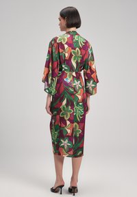 Satin-Kimono in lebhaften Farben mit floralen und geometrischen Mustern. Fließendes, knielanges Design mit weiten Ärmeln und einem Gürteldetail in der Taille.