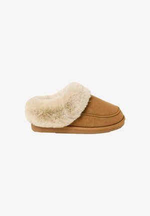 Tan suede slipper with a soft, cream faux fur cuff. Rounded shape, lightly textured sole, and stitched detailing on the upper.