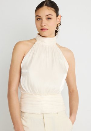 Ελεφαντόδοντο τοπ με λουρί στον αυχένα, πλισέ υφή, ψηλό γιακά και εσωτερική ραφή στη μέση. Λείο σατέν υλικό με απαλό γυαλιστερό φινίρισμα.