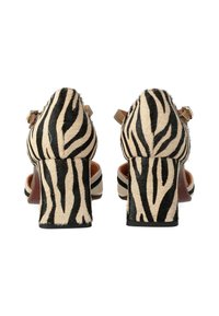 Scarpe con tacco alto in pelle con stampa tigre, dotate di un tacco spesso; caratterizzate da cinturini regolabili e una fodera interna color cuoio.