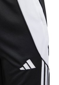 Schwarz-weiße Sporthose aus strukturiertem schwarzem Stoff mit einem glatten weißen Einschnitt. Enthält drei weiße Streifen und ein gesticktes Logo.