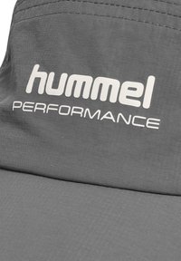 Graue Kappe aus leichtem Stoff mit dem weißen "hummel PERFORMANCE"-Logo, einer strukturierten Oberfläche und einem verstärkten Design.