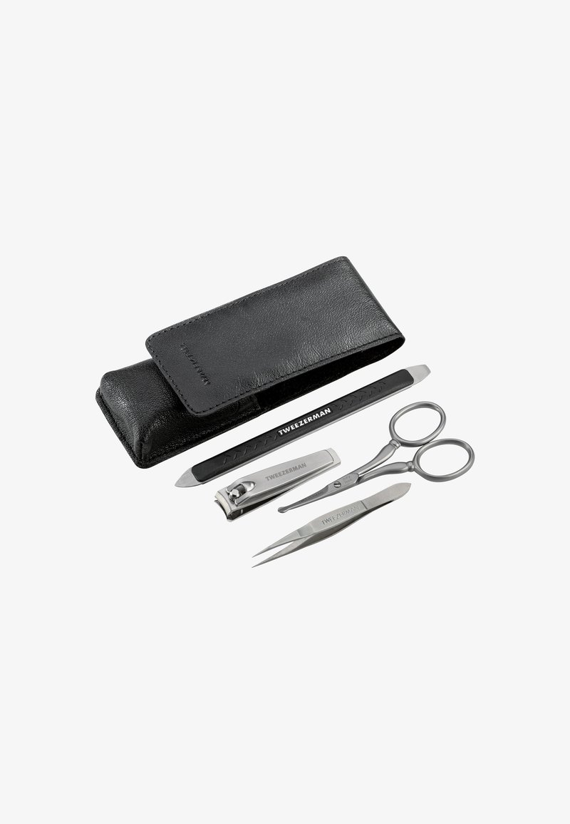 Étui en cuir noir contenant une lime à ongles, un coupe-ongles, une petite paire de ciseaux et une pince à épiler, tous étiquetés "Tweezerman" sur un fond blanc.