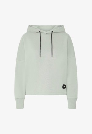 Lys grå cropped hoodie lavet af blødt stof. Har en sort snor, nedsatte skuldre og et rundt sort logo-patch på siden.