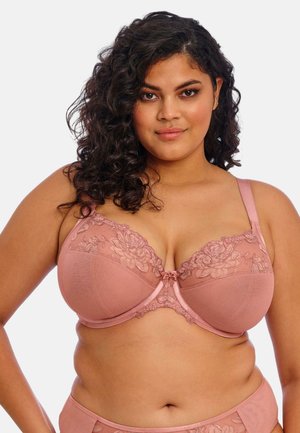 Soutien-gorge en rose blush avec des détails en dentelle florale sur les bonnets, tissu lisse, soutien-gorge à armatures et bretelles ajustables pour un maintien sécurisé.
