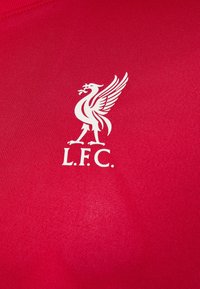Rotes Kurzarmtrikot aus strukturiertem Stoff. Mit einem weißen Liverpool FC-Logo und dem Schriftzug "L.F.C." darunter. Einfaches Design, ohne Muster.