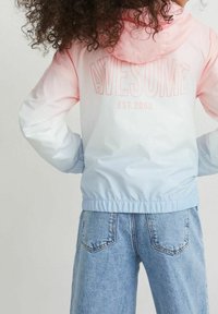 Farvet vindjakke i pink og lys blå med hætte og "AWESOME EST. 2008" trykt på ryggen i blød pink.