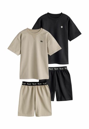 Zwei Sets aus legeren T-Shirts mit kurzen Ärmeln und Shorts, eines in Beige mit "WC"-Logo, eines in Schwarz mit Totenkopf-Logo, beidseitig mit elastischen Taillenbändern, die mit "Next" beschriftet sind.