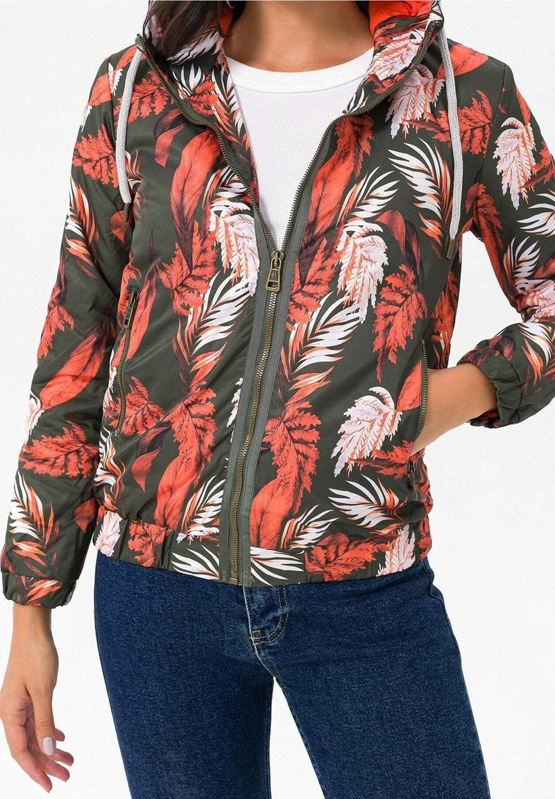 Huppumallinen pommikonepaita, jossa oliivinvihreä pohja ja punavalkoiset kukkakuviot, etuvetoketju sekä joustavat kalvosimet ja helma.