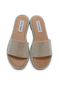 Sandali scivolosi beige con una larga fascia scintillante, caratterizzati da abbellimenti testurizzati e una suola piatta e liscia. Etichetta del marchio visibile all'interno.