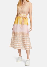 Šaty bez rukávů s výstřihem do V, které mají přechodovou barvu žluté, růžové a béžové. Texturovaná látka s páskem na zavázání v pase a splývavým lemem.