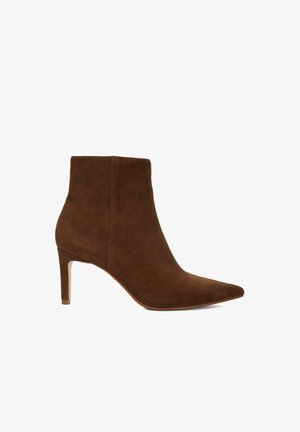 Bottine en daim marron à bout pointu et à talon fin et haut. Texture simple et lisse sans motifs ni accents visibles.
