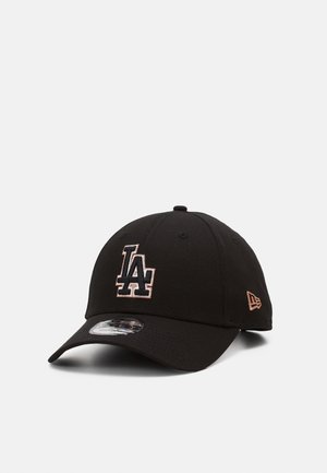 Casquette de baseball noire avec logo "LA" brodé en blanc et or rose sur le devant et logo New Era en or rose sur le côté, visière incurvée.